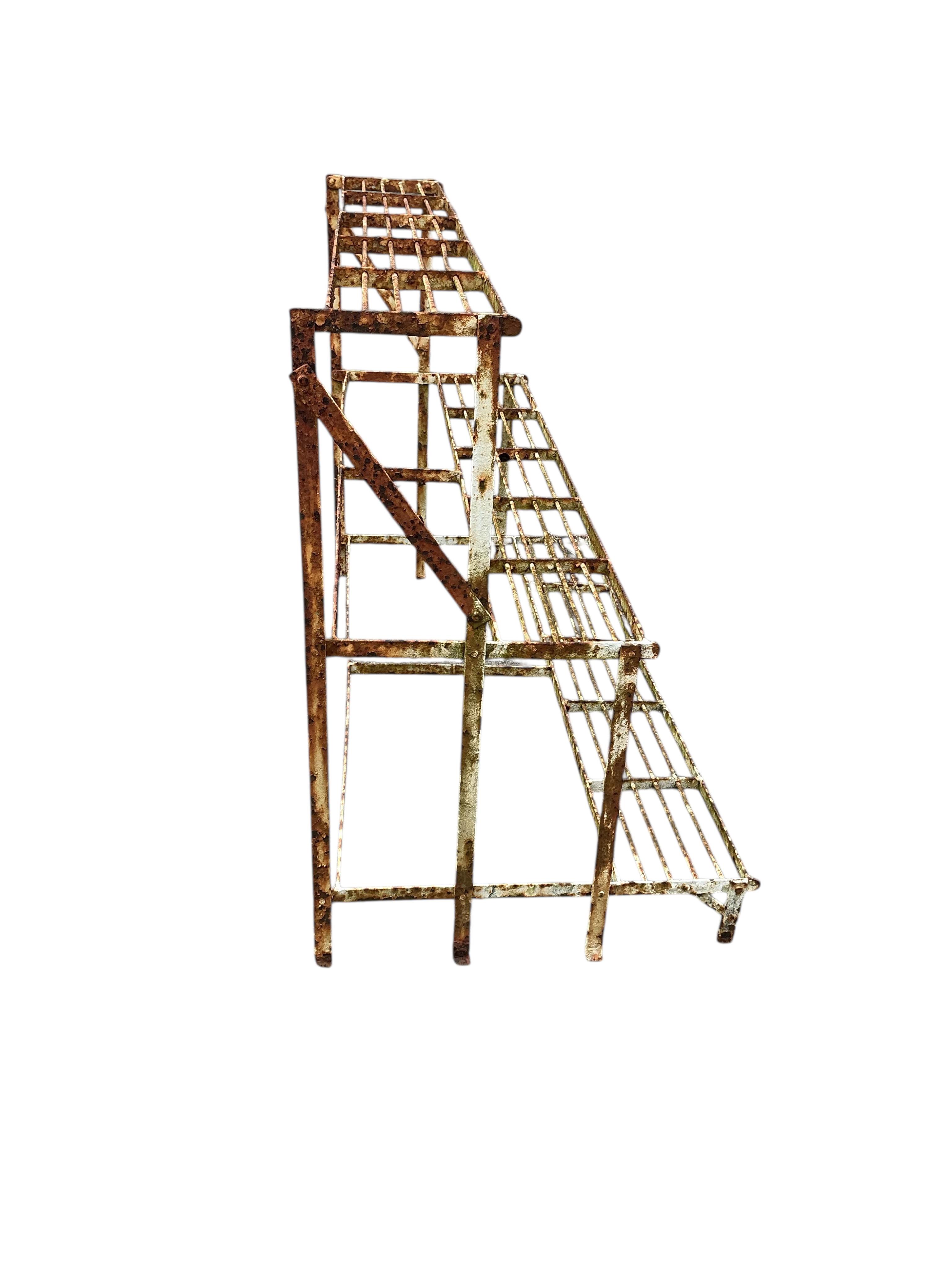 A painted wrought iron three tier pot stand, width 100cm, depth 50cm, height 73cm